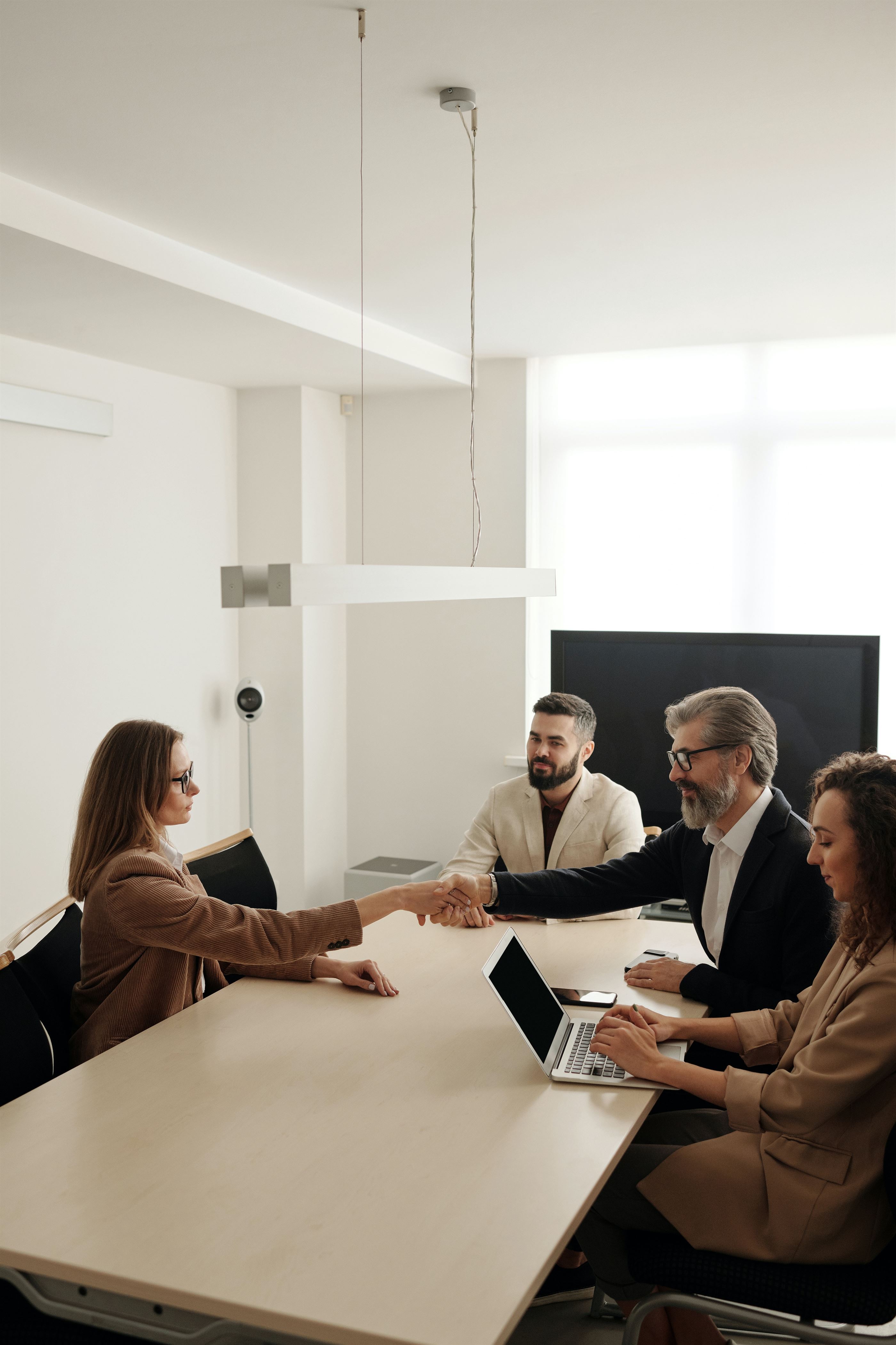 Accurate Title. Picture of an office with people shaking hands. Real estate title, 1031 exchange services in Mandeville, Covington, Madisonville, Hammond, Slidell. Title search, insurance, escrow services.